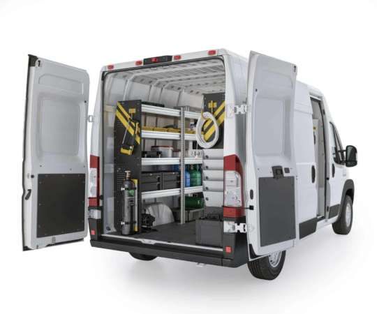 Inredning i en vit servicebil med hyllsystem och verktygsförvaring.